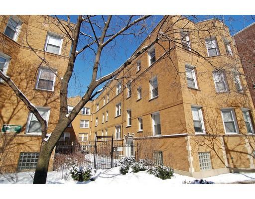 Front view of a multi-story brick apartment building during winter.