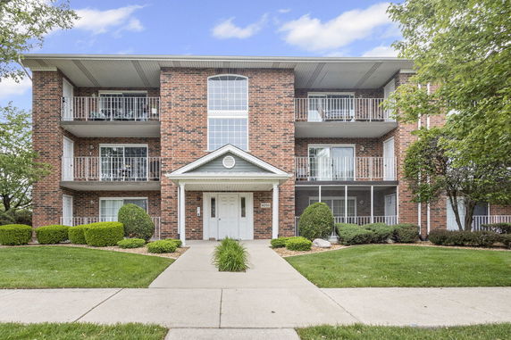 Front view of a multi-story brick building with balconies.