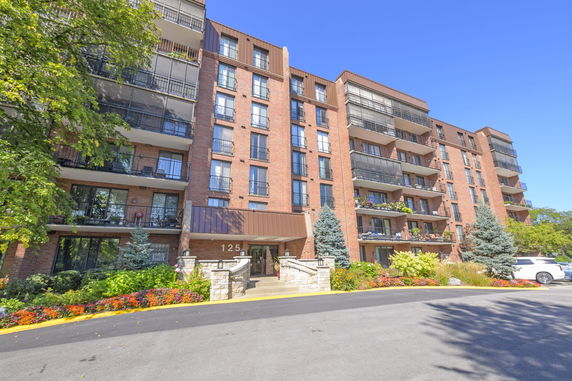 Front view of a multi-story residential building with balconies and entrance.