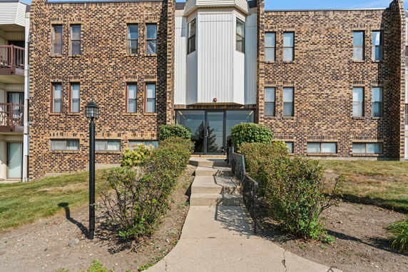Front view of a multi-story brick building with a central entrance.