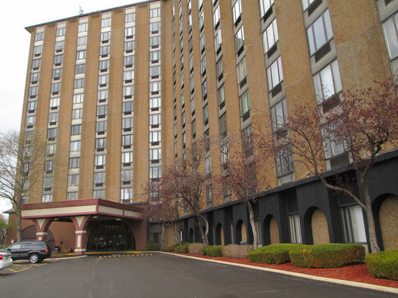 Front view of a multi-story building with an arched entrance.