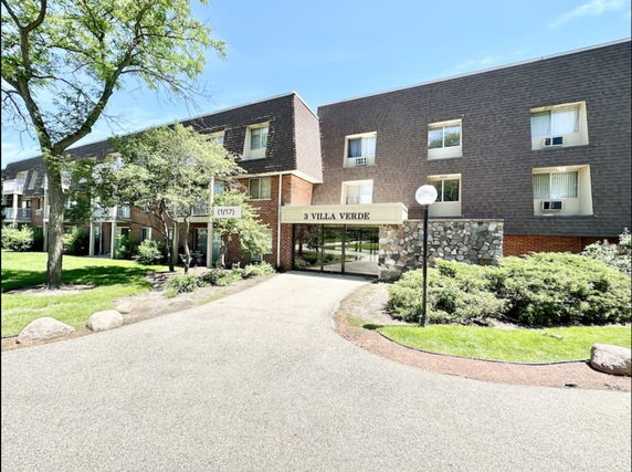 Front view of a multi-story residential building with a main entrance.
