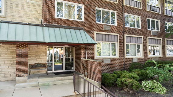 Front view of a multi-story building with a brick exterior and glass entrance.