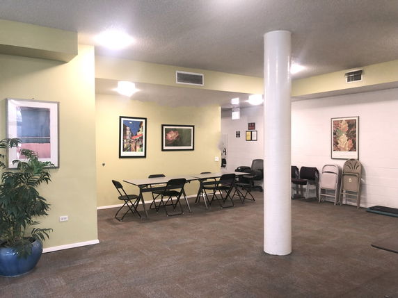Indoor recreation area with tables, chairs, and artwork on the walls.