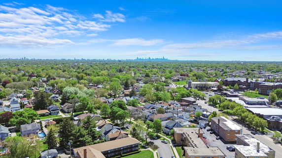 Panoramic view of residential area with distant city skyline.