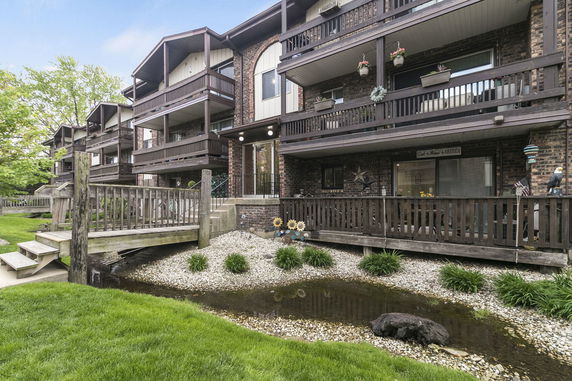 Front view of a multi-story apartment building with wooden balconies.