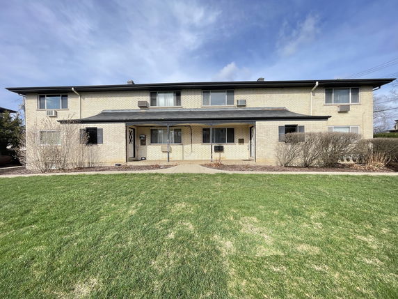 Front view of a two-story house with a brick facade.