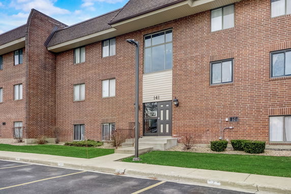 Front view of a brick multi-story residential building.