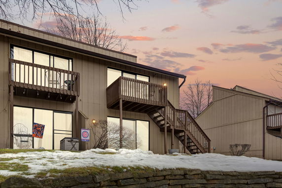 Front view of a multi-story house with balconies and outdoor staircase.
