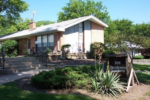 Front view of a single-story house with a sloped roof and chimney.