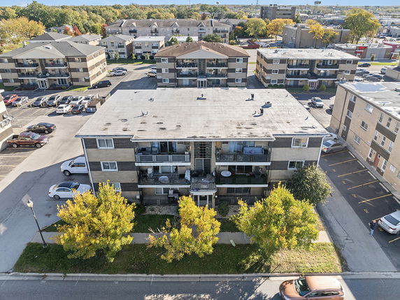 Front view of a multi-story apartment building with balconies.
