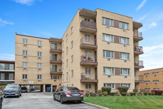 Front view of a multi-story apartment building with balconies.