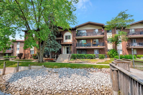 Front view of a multi-story residential building with balconies.