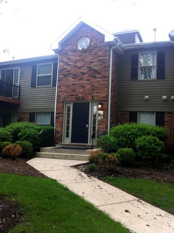 Front view of a brick and siding two-story building with a central entrance.