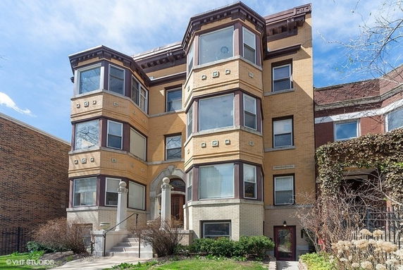Front view of a three-story brick building with bay windows.