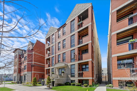Front view of a multi-story apartment building with balconies.