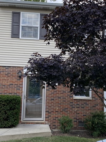 Front view of a two-story house with brick and siding exterior.