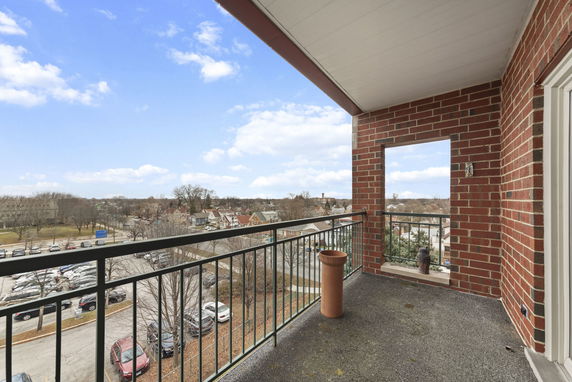 View from a balcony showing a parking area and residential neighborhood.