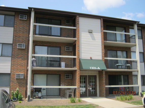 Front view of a multi-story apartment building with balconies.