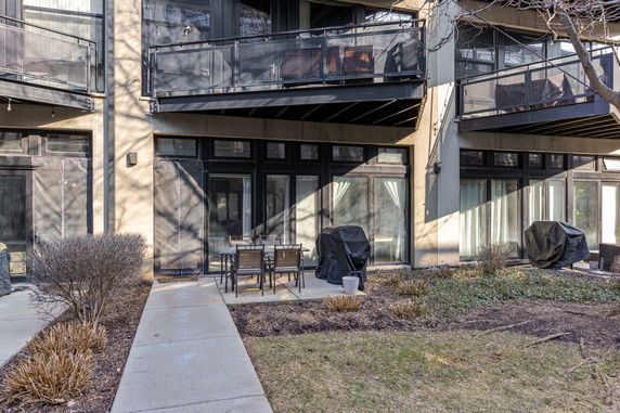 Front view of a building with balconies and a small outdoor patio area.