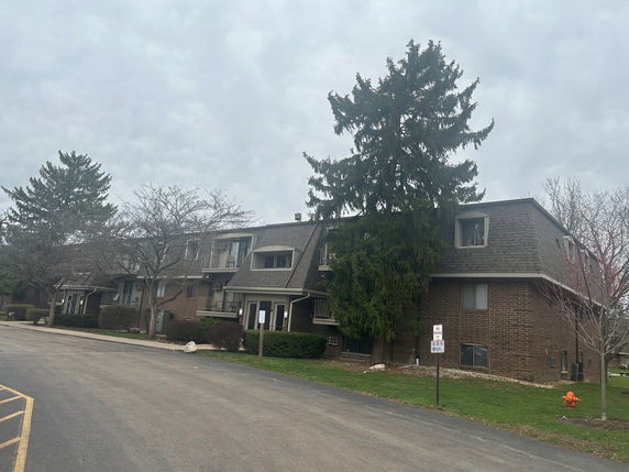Front view of a two-story brick building with multiple entrances and windows.