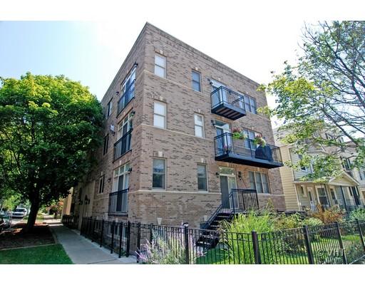 Front view of a multi-story brick apartment building with balconies.
