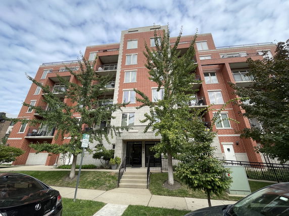 Front view of a multi-story residential building with balconies.