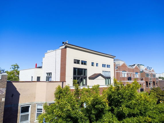 Front view of multi-story buildings with brick and stucco exteriors.