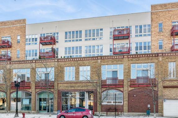 Front view of a multi-story building with brick exterior and balconies.