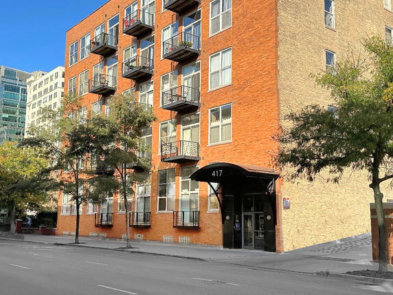 Front view of a multi-story brick building with balconies.