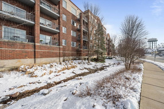 Side view of a multi-story brick apartment building with balconies.