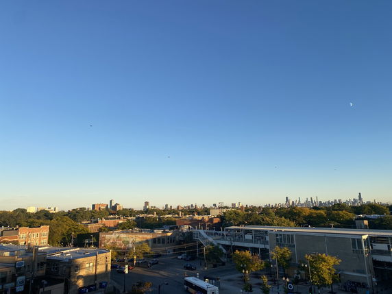 Panoramic view of a city skyline with clear blue sky.