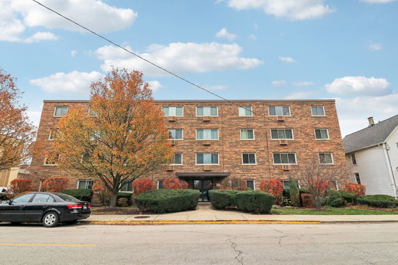 Front view of a four-story brick apartment building.