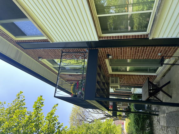 Front view of a multi-story house with brick and siding exterior and a small balcony.