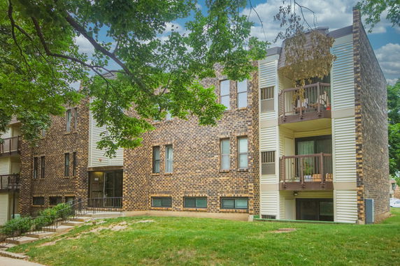 Front view of a brick apartment building with balconies.