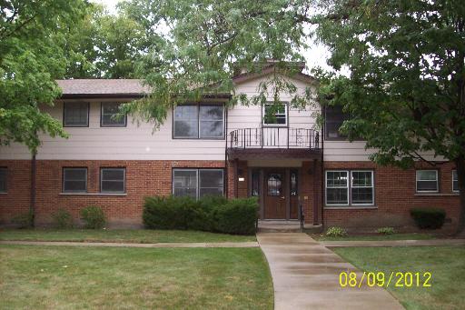 Front view of a two-story building with a brick facade and entrance steps.