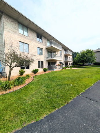 Front view of a three-story apartment building with balconies.