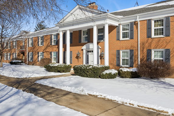 Front view of a large two-story brick building with white columns.