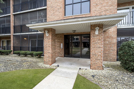 Front view of a multi-story brick building with an entrance walkway.