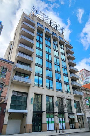 Front view of a multi-story building with large windows and balconies.