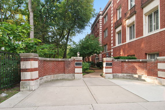 Front view of a brick residential building with a gated entrance.