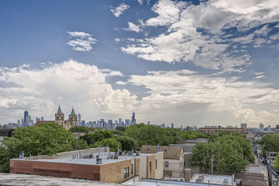 Panoramic view of a city skyline with buildings and trees in the foreground.