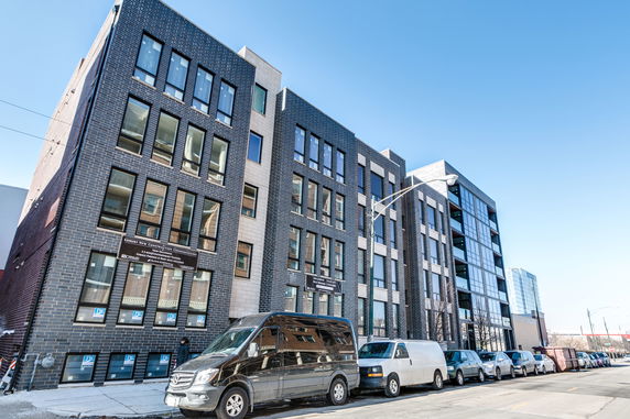 Front view of a modern multi-story building with large windows.