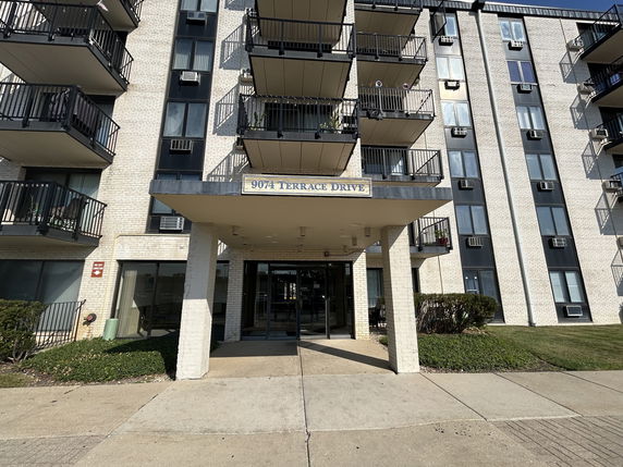 Front view of a multi-story residential building with balconies.