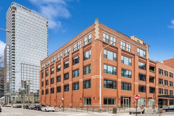 Front view of a multi-story brick building on a street corner.