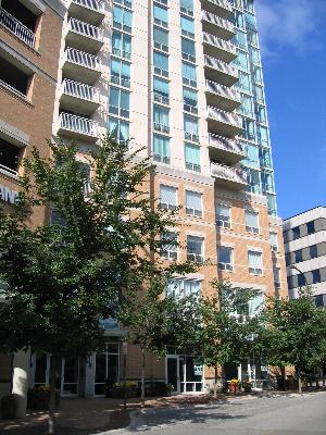 Front view of a multi-story building with balconies and large windows.