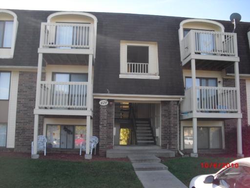 Front view of a multi-story apartment building with balconies.