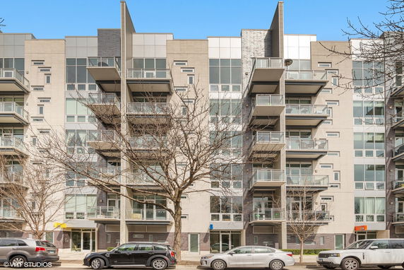 Front view of a modern multi-story apartment building with balconies.