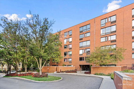 Front view of a multi-story brick building with large windows.