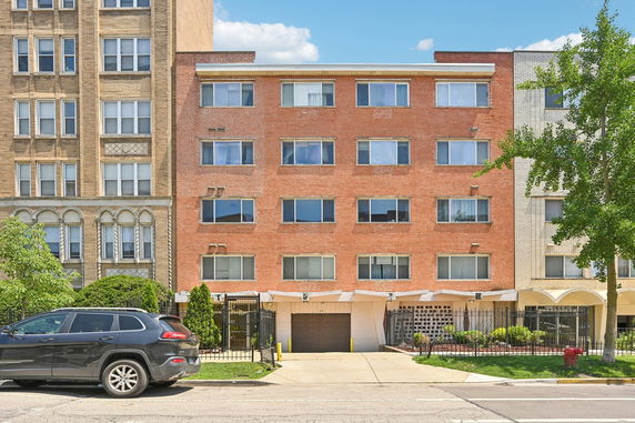 Front view of a multi-story brick building with several windows and an entrance.